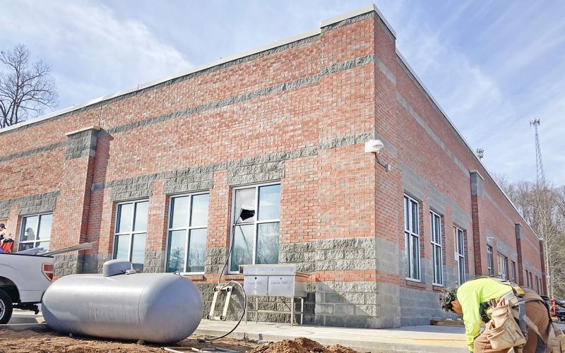 A construction worker labors outside the new Lumpkin County College &amp; Career Academy building on the LCHS campus.