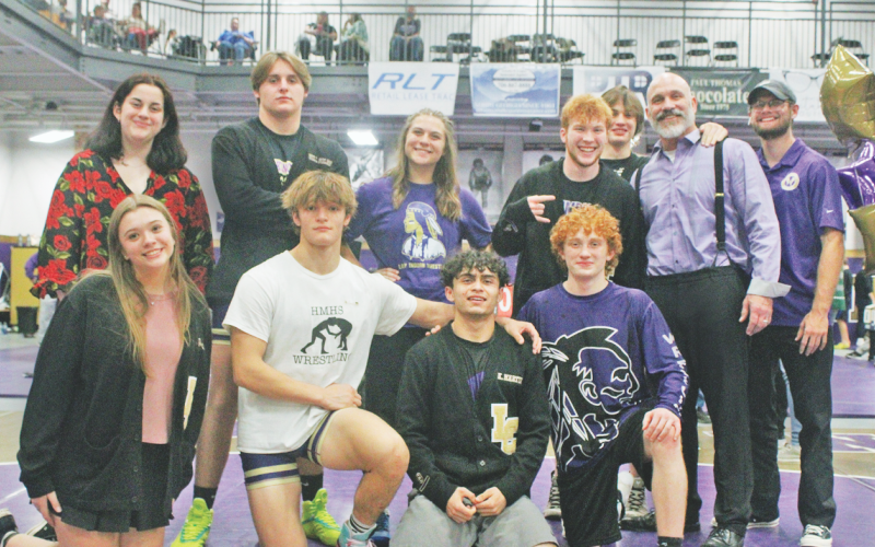 Head Coach Sean Hage and Coach Cale Goss gather with the Lumpkin wrestling seniors.