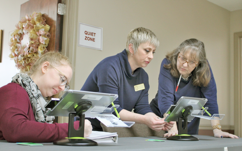 Local election officials (from left) Brittani Conner, Robin McIntosh and Crystal Dozier use a poll pad to activate ballot cards for testing ahead of the upcoming Presidential Preference Primary.