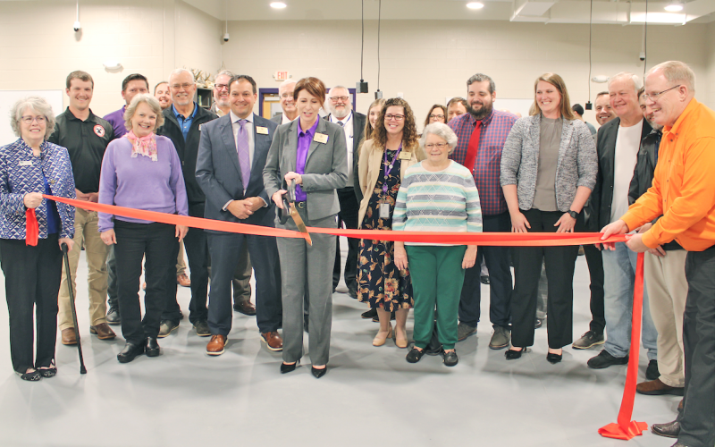 Lumpkin County Superintendent Sharon Head cuts a ceremonial ribbon in the College &amp; Career Academy’s agricultural lab as local school board members, elected officials and project managers look on.