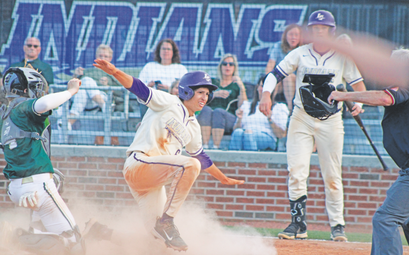 Lumpkin County's Alejandro Narvaez calls himself safe after sliding into home plate.