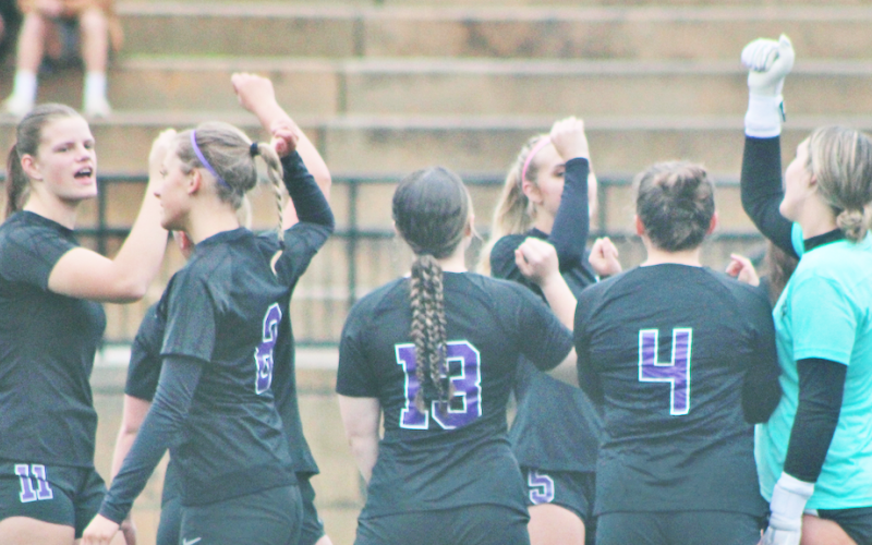The lady Indians soccer team huddles together before storming the field.
