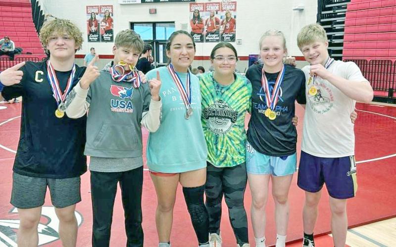 Lumpkin wrestlers Nathan Nielsen, Liam Nielsen, Maddie Mendoza, Nattalie Mendoza, Greta Garbuzovas and Xander Nielsen share a moment at the Warrior Invitational.