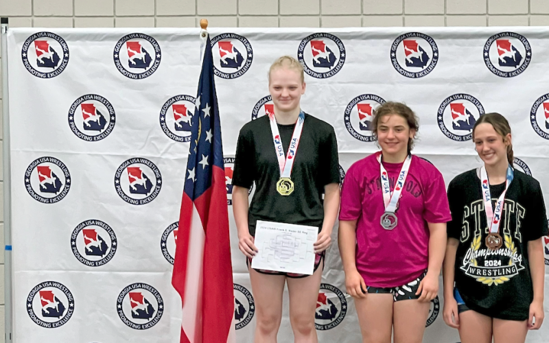 Greta Garbuzovas (left) stands atop the podium at the Southeast Regional Championships.