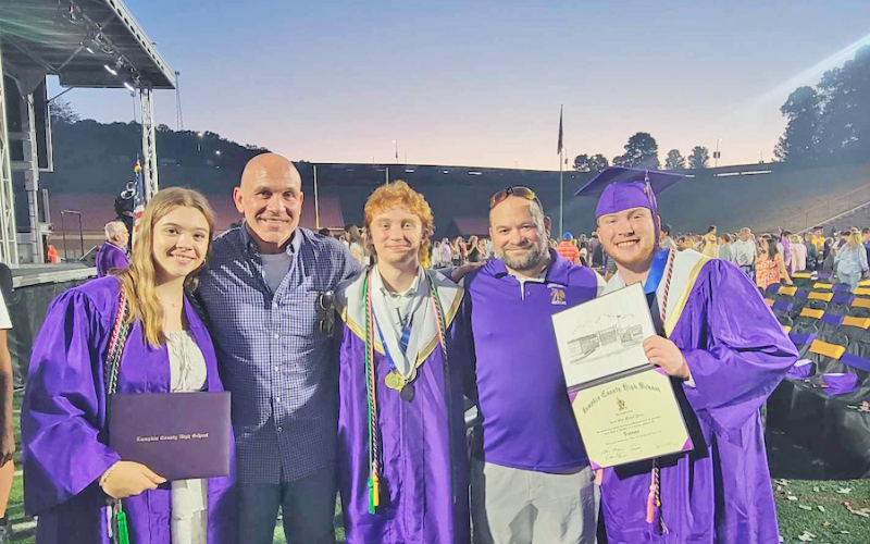 Paisley Thomas, Wrestling Head Coach Sean Hage, Austin Marshall, Assistant Coach David Matthews and Jacob Pricer share a special moment at their graduation ceremony.