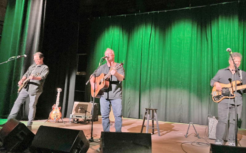 Shawn Mullins (center) is pictured along with band mates Patrick Blanchard on electric guitar and Tom "Panda" Ryan on bass on the stage of The Holly Theater.