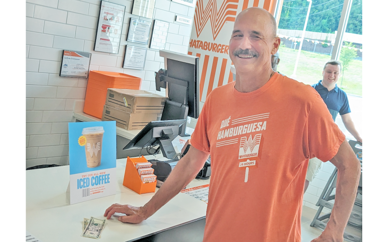 University of North Georgia professor Steve Smith savors his status as the first official customer at the newly opened Whataburger on the corner of Morrison Moore Parkway and Riley Road.