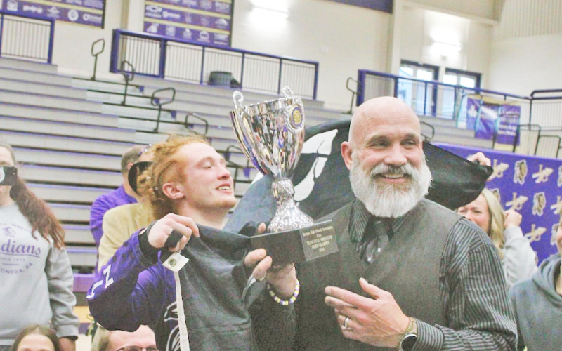 Lumpkin Wrestling Head Coach Sean Hage hoists the team’s Dual State Championship trophy at the conclusion of last year’s wrestling season.
