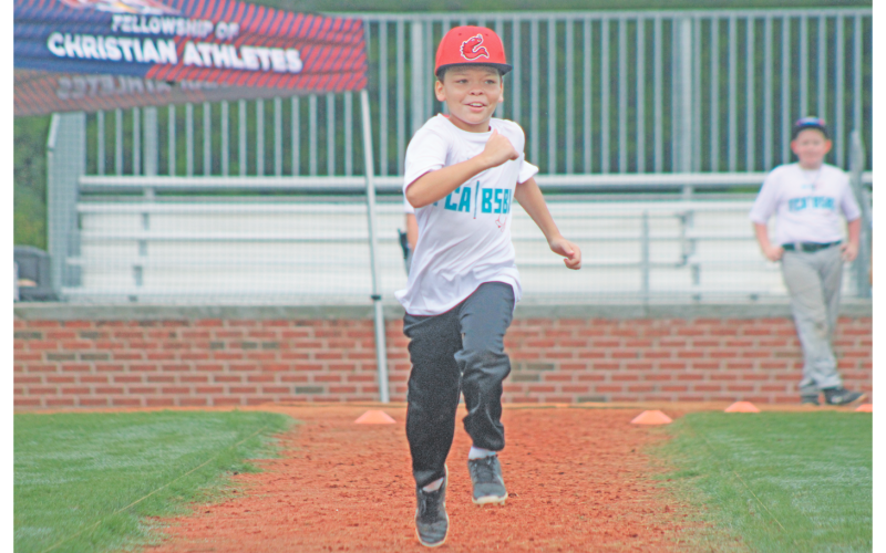 Blake Huff sprints to first during the FCA baseball summer camp at Lumpkin County High School.
