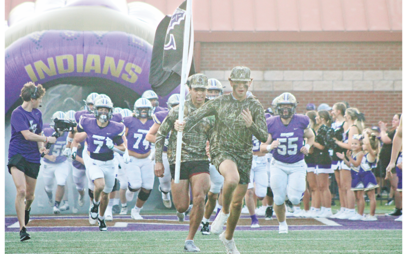 The Lumpkin County High School football team races onto the field ahead of their game against Hart County.