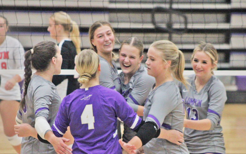 The LCHS volleyball team celebrates its victory over Rabun after winning the third set.