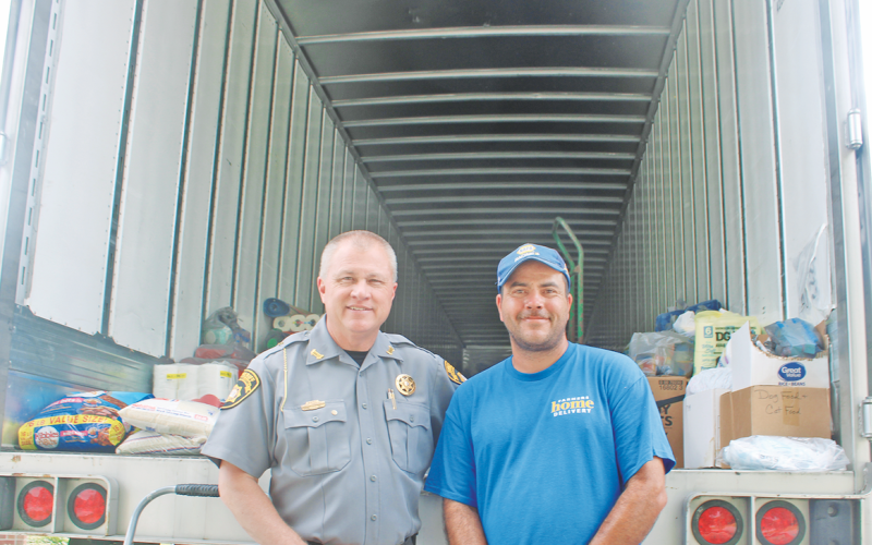 Sheriff Stacy Jarrard and volunteer relief organizer Donald Hupp are pictured in front of their second hurricane supply trailer last Thursday. By Monday, the same trailer was completely filled and headed for a church in Asheville, North Carolina.