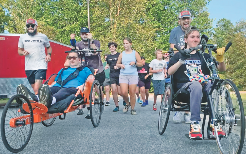 Race for a Reason runners and rollers head out on a recent jog through Yahoola Creek Park as Shari Carpani, seated on left, gets a boost from her running mates, Ben Paddick and David Tate, while Nathan Valencia, seated on right, and James Daniel keep things rolling.