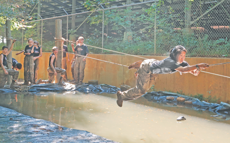 Ru Helvie conquers the commando rope cross during the team’s meet in Heart County.