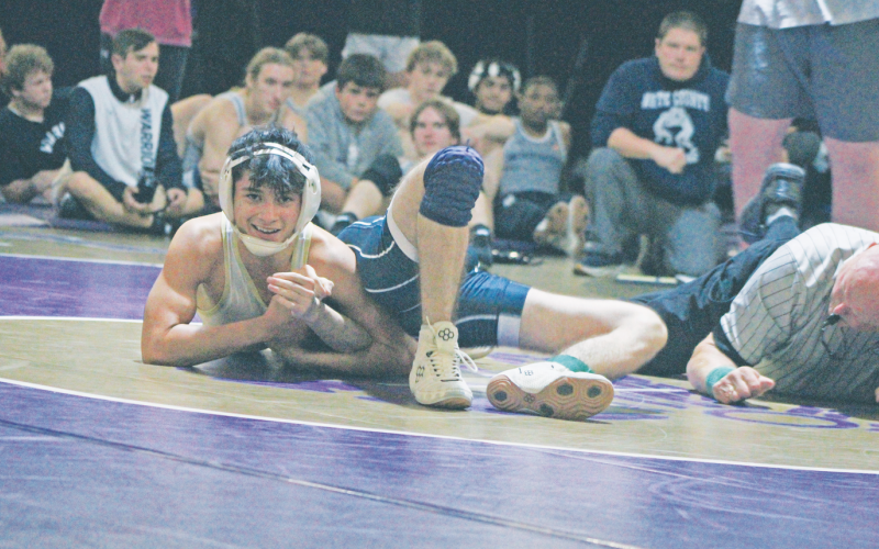 Lumpkin County High School wrestler Geovany Hernandez smiles as he pins his White County opponent.