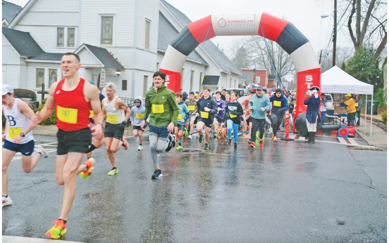 Eventual race winner Matt Bird (left) leads the pack away from the starting line of the Wimpy Mile on Saturday morning.  Despite a cold, steady rain, participants showed up in impressive numbers for the fourth-annual charity event. (Photo by John Bynum)