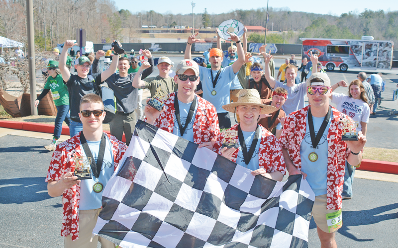 After the dust settled in the final round of the Grocery Grand Prix, the team members from Sigma Omega 1 (not affiliated with UNG) hoisted the winners’ trophies. Pictured, from left: Charlie Hammock, Chuck Forbes, Chase Martin and Jeremy Calhoun celebrate with the checkered flag.
