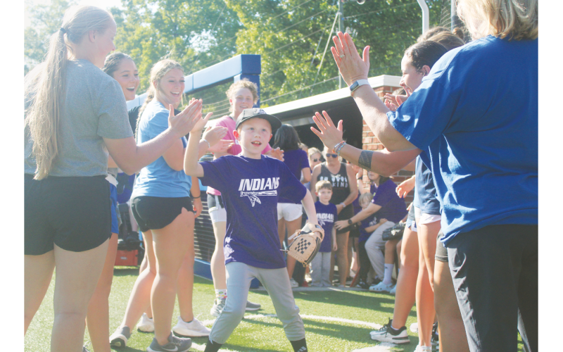 Local athlete Tommy England storms out of the dugout and onto the field ahead of the Heroes game.