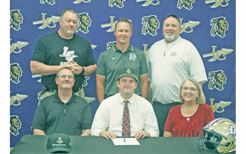 Matthew Reece signs his commmitment surrounded by his coaches and parents.