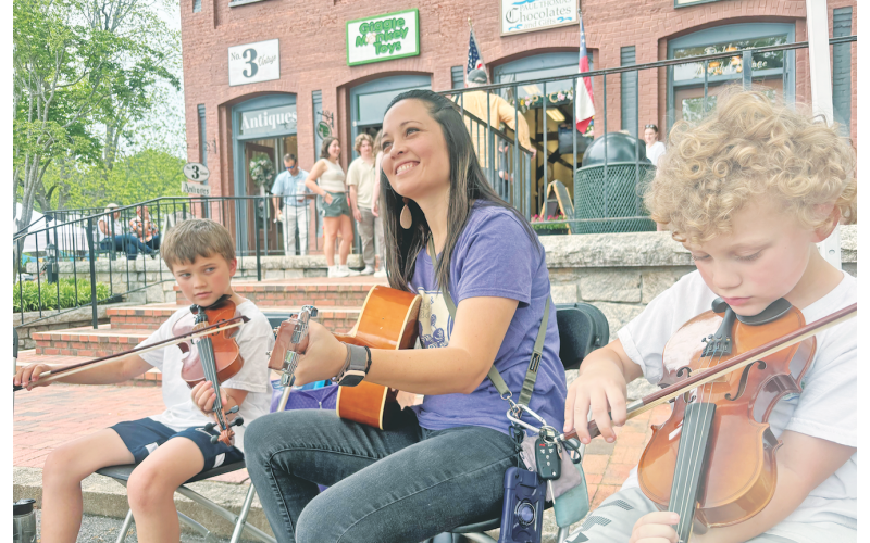Cottrell Elementary School music teacher Amanda Barton and Georgia Pick &amp; Bow students Emerson Barton, left, and Montgomery Barton add to the musical soundtrack of Bear on the Square on Sunday.