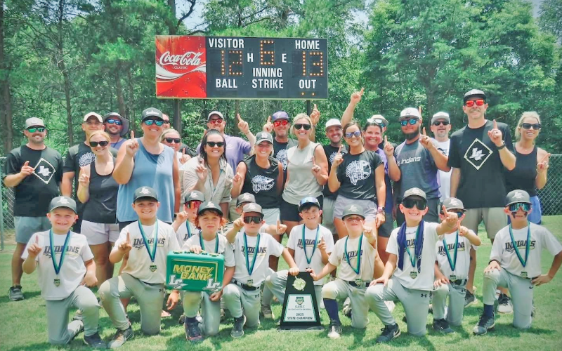 The Lumpkin County 8U team, backed by their coaches and parents, celebrate the State Championship victory.