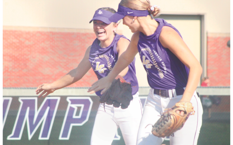 Lumpkin County High School softball players Maddox Henderson (left) and  Abi Kate Webb celebrate a great play at last week's summer game.