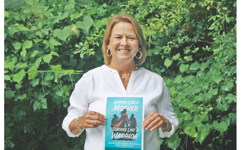 Dahlonega resident Lisa Raber proudly displays the cover of an upcoming self-help book she co-authored.
