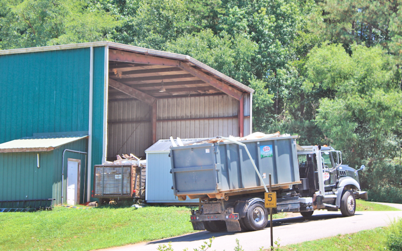 A truck hauls a load of garbage towards the Lumpkin County Transfer Station’s main building.