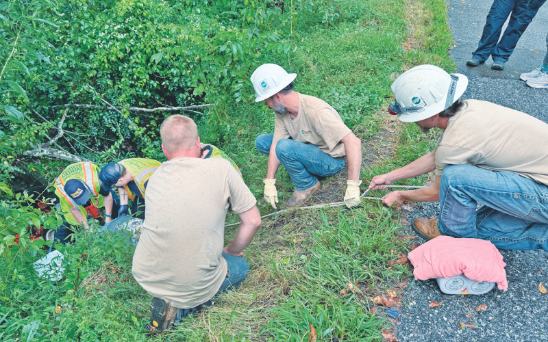 Neighbors and passersby joined together to help rescue Lamar Laird from the bottom of a steep embankment after the local resident was pinned beneath his riding mower last Tuesday.