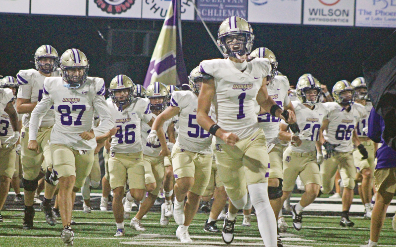 Mac Powell leads the Lumpkin County team onto the field to face off against North Hall.