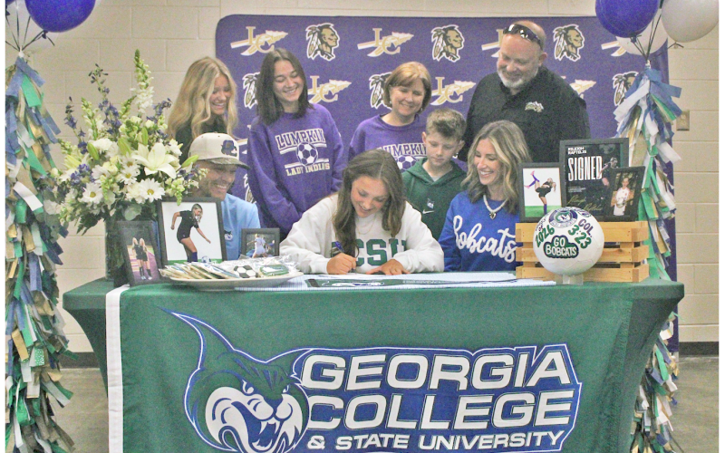 Rileigh Raftelis signs her commitment to attend Georgia College as a soccer player.
