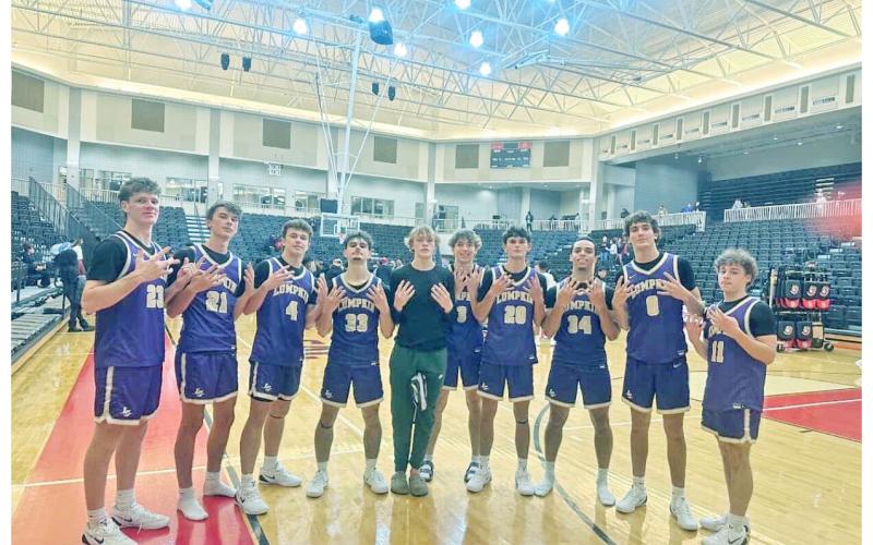 The Lumpkin County boys basketball team celebrates their historic start after defeating GAC.