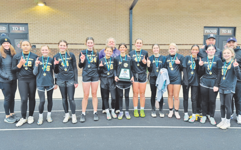 The 14U flag football team shows off their new State Championship trophy.