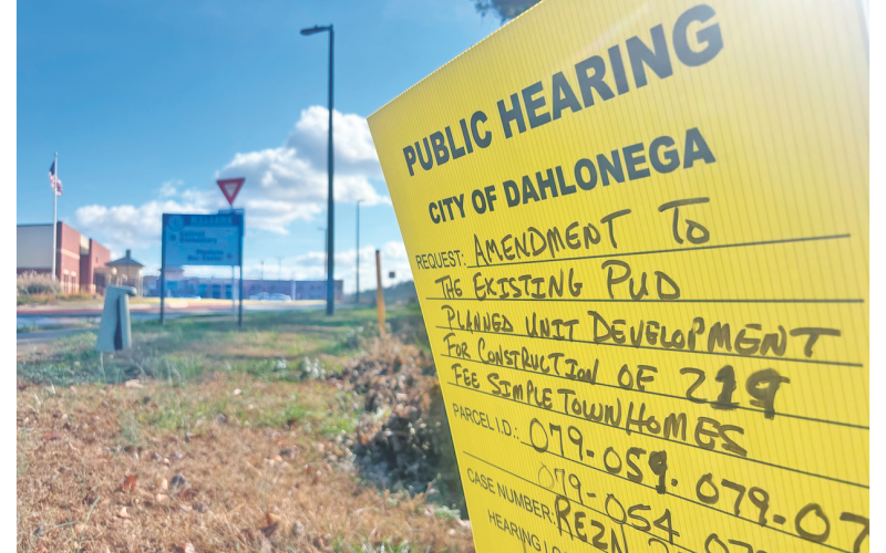A sign just before the roundabout in front of the new Aquatic Center on Pinetree Way advertises two December public hearings.