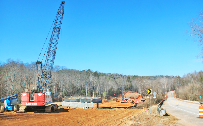 Heavy construction equipment can be seen next to the Chestatee River bridge on Highway 52 East. A section of GDOT’s replacement bridge has already been installed over the river.