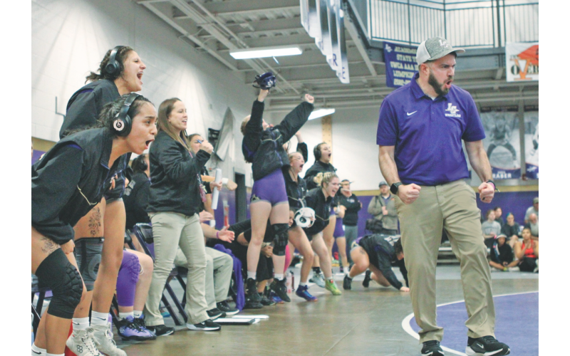 Coach Scott Degraff and the Lumpkin County Girls wrestling team celebrate a pin during one of their duals.