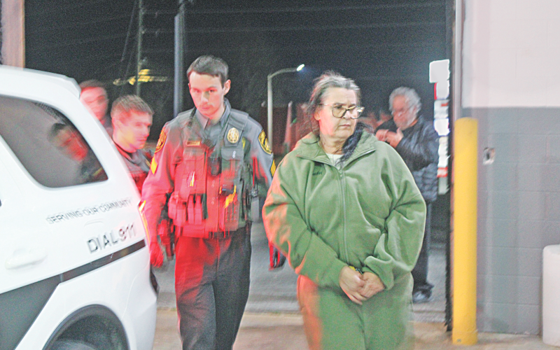 Magdalena Magadan is escorted by Deputy Zachary Bogue into the Lumpkin County Detention Center where the Florida resident was charged with theft by deception.