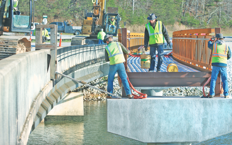 City contractors work to install segments of the much-anticipated pedestrian bridge at Lake Zwerner.