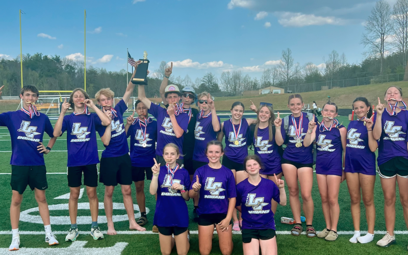 The middle school track team shows off their newly-earned hardware at the Region Championships.