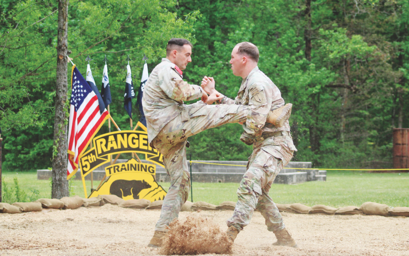 Staff Sergeant Hunter Green (right) catches a kick from Staff Sergeant Ben Ronemus during a hand-to-hand combat demonstration at Camp Frank D. Merrill’s 5th Battalion Army Rangers Open House.