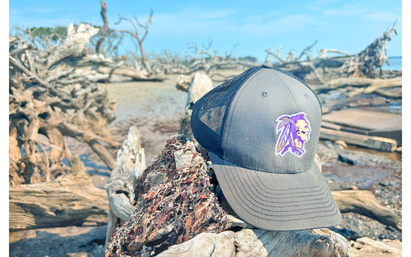 Sports writer Eligha Roper’s Lumpkin County sports cap takes a vacation at Driftwood Beach.