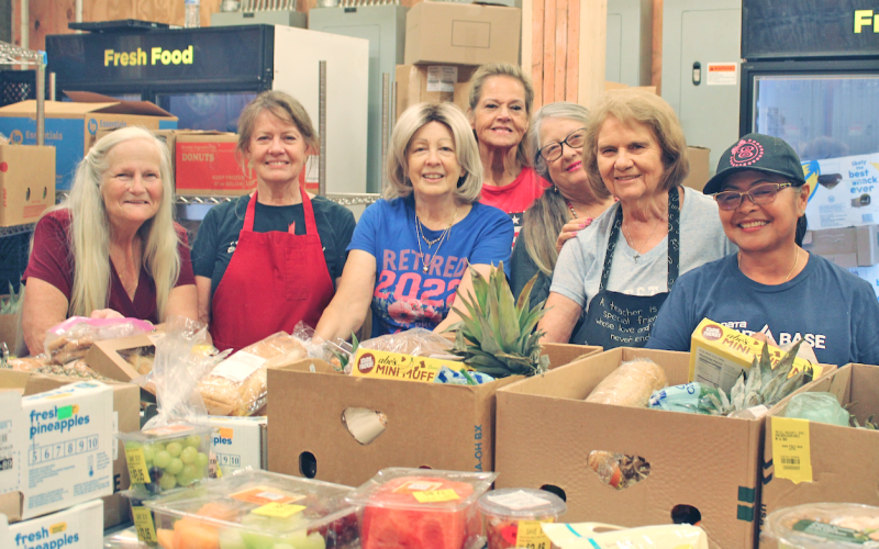 Food bank volunteers (from left) Monica Powell, Elaine Dinsmore, Suzanne Depew, Vickie Foster, Patricia Taylor, Donna Sears and Eugenia Thurmond are all smiles as they prepare boxes for pick-up.