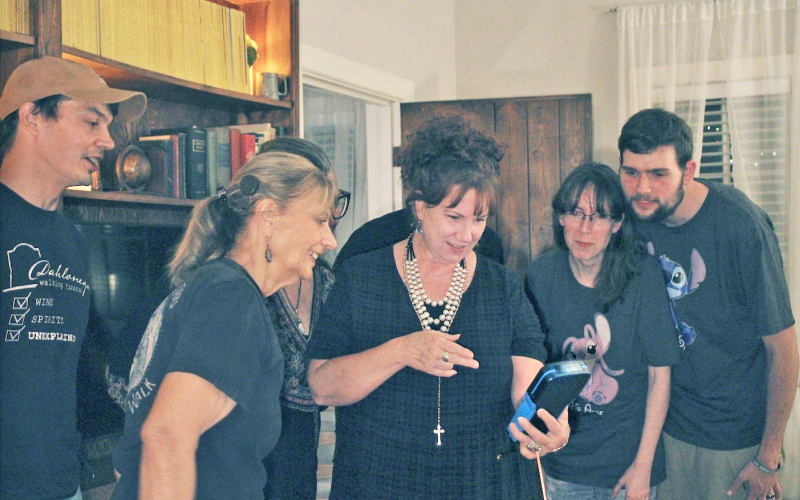 Attendee Kim Pyron holds the Para4ce Polterscript Device during a local paranormal investigation as (from left) Dahlonega Walking Tours co-owners Jeremy Sharp and Penny Sharp look on with their guests.