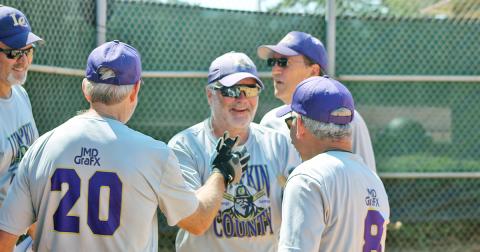 Lumpkin County Miners player/coach John “Da Boss” Daley gets a healthy dose of high-fives after belting a three-run, inside-the-park home run versus the Dahlonega Gold during a Clayton League doubleheader last week.