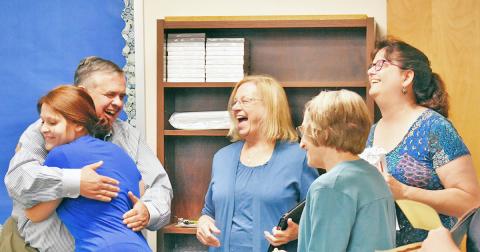 GED graduate Jennifer Welch hugs Geoffrey Kridel of Lumpkin Literacy alongside board members Barbara Adams, Shirley Christman and Karen Shepherd.