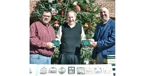 Local philanthropist and merchant Thomas Scanlin (center) spent a little time recently playing Santa to the community, gifting both Lumpkin County and the City of Dahlonega with complete sets of the Community Helping Place Official Dahlonega Christmas Ornament. Scanlin said he hopes the sets will be on permanent public display for all to enjoy. Accepting the gifts are (left) Lumpkin County BOC Chairman Chris Dockery and Dahlonega Mayor Sam Norton.