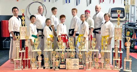 Local karate competitors pictured (from left): Travis Hamner (instructor), Christopher Frausto, Brad Bowelle (chief instructor, owner), Ella Greene, Owen Mondell, Aiden Marshall, Austin Marshall, Lindsey Greene, Alexis Weir, Wayne Marshall (instructor) and Josiah Payne. Not pictured: Jameson Ballard, Nathan Voci, Tyler Voci and Luke Scheinoha.