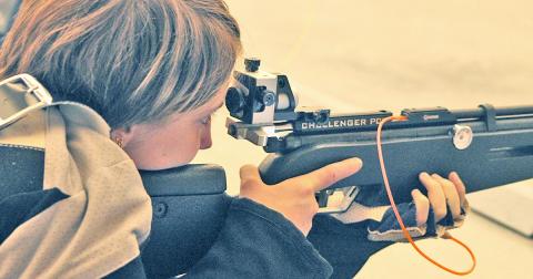 LCHS rifle team member Liv Lusky looks down her sights during the prone position portion of competition versus North Gwinnett last week.