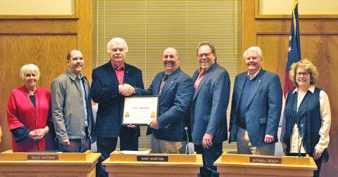 Members of the city council wish Bruce Hoffman (third from left) a fond farewell at his final city council meeting on Monday, Dec. 2. The council presented Hoffman with a plaque in recognition of his eight years of service on the local governmental body.