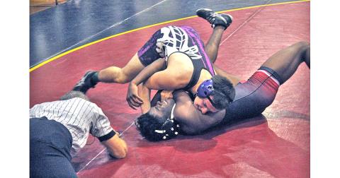 Indians wrestler Jeremiah Holmes gets his opponent on his back for a win by pin during the Trojan Invite at Lassiter High School on Saturday, Dec. 21.